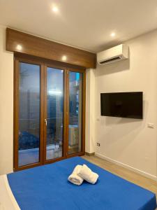 a bedroom with a blue bed with a flat screen tv at Sorrento Bay Apartment in Sorrento