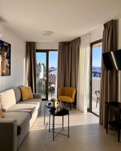 una sala de estar con un sofá y una mesa en 9 Muses Holiday apartments, en Lárnaca 10 fotos más