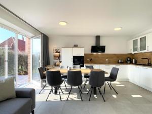 Una cocina y un comedor con mesa y sillas. en Am Dahmer Leuchtturm 23e, en Dahme