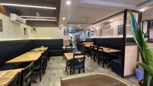 a dining room with wooden tables and chairs at Hotel Laxman Ganga in Rishīkesh