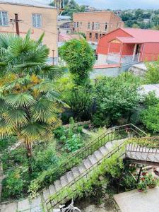 an outdoor garden with stairs and trees and buildings at Central apartments in Kutaisi