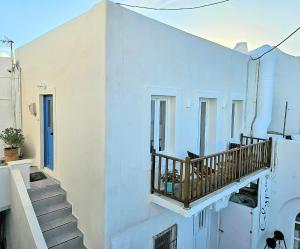 a white building with a staircase and a balcony at Domus MarZou Limanaki in Naousa