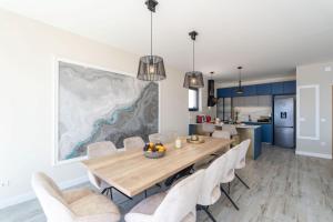 a dining room with a wooden table and white chairs at Green Horizon Sea Views Villa in Dubrovnik