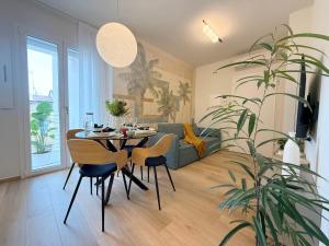 un soggiorno con tavolo, sedie e una pianta di Central suite bilocale in centro con garage a San Benedetto del Tronto