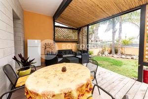 eine Terrasse mit Tisch und Stühlen auf einem Deck in der Unterkunft Oasi delle Meraviglie in Torre dell'Orso