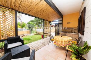 eine Terrasse mit Tisch und Stühlen und eine Küche in der Unterkunft Oasi delle Meraviglie in Torre dell'Orso