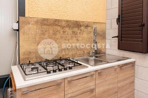 eine Küche mit Herd und Spüle in der Unterkunft Oasi delle Meraviglie in Torre dell'Orso + 50 Fotos