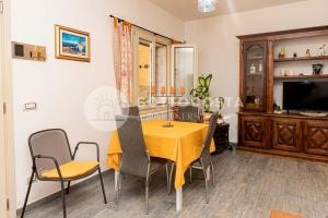 ein Esszimmer mit einem gelben Tisch und Stühlen in der Unterkunft Oasi delle Meraviglie in Torre dell'Orso