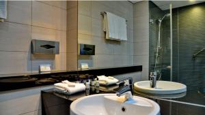 a bathroom with two sinks and a mirror at ANEW Hotel Roodepoort Johannesburg in Roodepoort