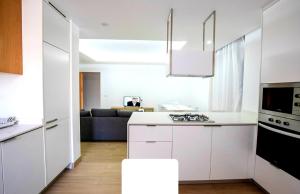 Una cocina con gabinetes blancos y un horno de estufa. en Rita Apartamento, en Mindelo 4 fotos más