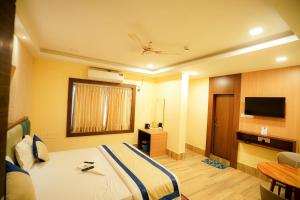 a hotel room with a bed and a television at The Divan in Bhubaneshwar