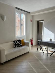 a living room with a white couch and a table at Appartamento in pieno centro a tre minuti dalla spiaggia in Finale Ligure