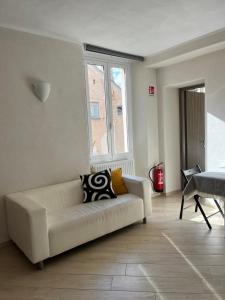 a white couch in a living room with a window at Appartamento in pieno centro a tre minuti dalla spiaggia in Finale Ligure