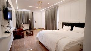 a bedroom with a large white bed and a desk at Felicia Meadows in Dhanaulti