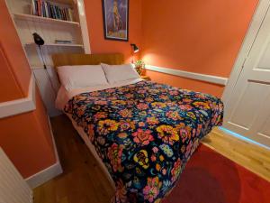 ein kleines Schlafzimmer mit einem Bett mit einer Blumendecke in der Unterkunft Strathpeffer Holiday Cottages in Strathpeffer