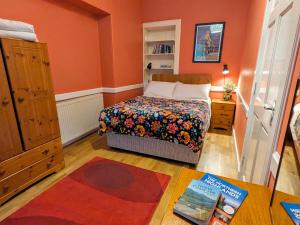 ein kleines Schlafzimmer mit einem Bett und einem Bücherregal in der Unterkunft Strathpeffer Holiday Cottages in Strathpeffer + 13 Fotos