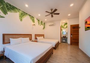 a bedroom with two beds and a ceiling fan at Khách sạn gần biển Viva Tuy Hoà Phú Yên in Phường Sáu