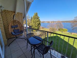 a porch with chairs and a table and a view of the water at Monteurzimmer 2 Mit Seeblick in Zeuthen