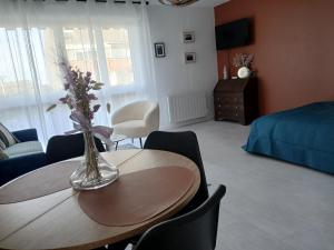 a living room with a table with a vase of flowers on it at La Cabine du Man, classé 2 étoiles in Roscoff