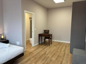 a bedroom with a desk and a bed and a table at Le Vele Rooms in Trieste