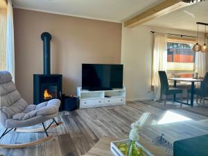 a living room with a fireplace and a television at Urlaub am Schwarzbach mit Sauna und Whirlpool Haus Johanna in Butgenbach