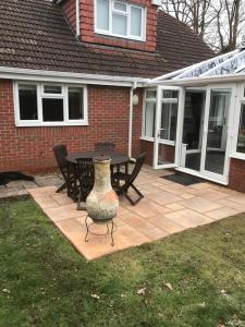 a patio with a table and chairs and a vase at Hillhouse in Hythe +3 photos