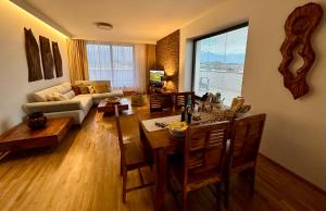 a living room with a couch and a table and chairs at Vysoké Tatry - ISC RESORT in Mlynica