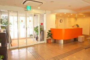 an office with an orange counter in a room with plants at Chisun Inn Karuizawa in Karuizawa
