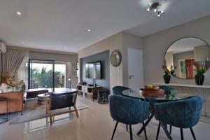 内尔斯普雷特Perfect Hideaway的客厅里有一张桌子和蓝色的椅子