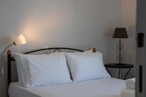 a bedroom with a bed with white pillows and a lamp at Seaside Escape in Kalamata