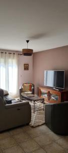 een woonkamer met een bank en een flatscreen-tv bij Maison Gorges du Gardon in Collias