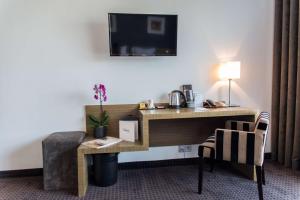 a hotel room with a desk and a chair at Best Western Hôtel De La Cité & Spa in Guérande