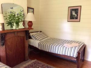 Alexandra Farmstay في ألكسندرا: غرفة نوم صغيرة مع سرير ومرآة