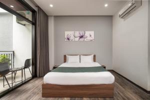 Un dormitorio con una cama, una mesa y un escritorio. en Villa biển Mỹ Khê DaNang 9 phòng ngủ, en Da Nang 17 fotos más