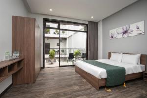 una habitación de hotel con una cama y un balcón en Villa biển Mỹ Khê DaNang 9 phòng ngủ, en Da Nang