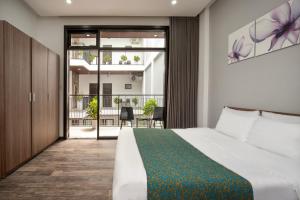 una habitación de hotel con una cama y un balcón en Villa biển Mỹ Khê DaNang 9 phòng ngủ, en Da Nang