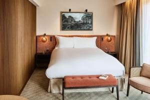 a hotel room with a large bed and a chair at Sofitel Brussels Europe in Brussels +165 photos