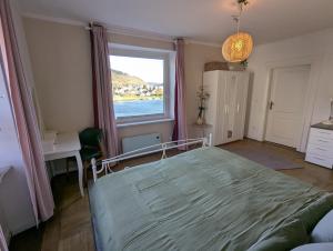 een slaapkamer met een bed en een groot raam bij Voll ausgestattete Wohnung mit Moselblick in Alf +9 foto's