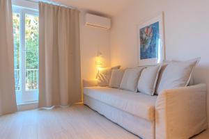 a living room with a white couch and a window at Villa Yadranka with Sea view in Strunjan
