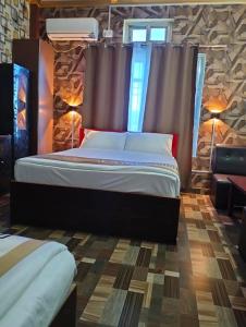DhangadhiSitar Hotel and Restaurant的一间带大床和石墙的卧室