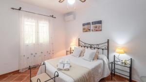 a bedroom with a bed with two shoes on it at Villa Jose y Ana Antequera - La Joya by Ruralidays in Antequera +27 photos