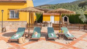 a group of chairs and tables and a house at Villa Jose y Ana Antequera - La Joya by Ruralidays in Antequera