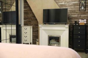 a bedroom with a fireplace with a tv on top of it at Vives les vacances 4 Ch in Arques-la-Bataille