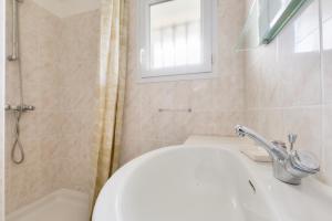 een badkamer met een wastafel en een toilet en een raam bij Maison de vacances familiale proche de la plage in Andernos-les-Bains +23 foto's