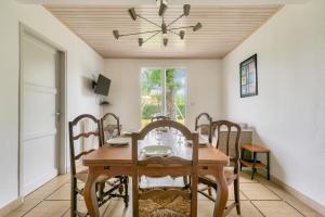 een eetkamer met een houten tafel en stoelen bij Maison de vacances familiale proche de la plage in Andernos-les-Bains