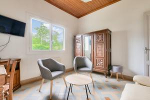 een woonkamer met twee stoelen en een tafel bij Maison de vacances familiale proche de la plage in Andernos-les-Bains
