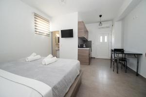 a bedroom with two beds and a kitchen with a table at Litmus in Fira