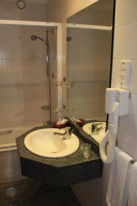 a bathroom with a sink and a bath tub at Seculo Hotel in Porto