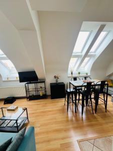 - un salon avec des lucarnes, une table et des chaises dans l'établissement Central, Cozy & Stylish Apartment with Views, à Prague