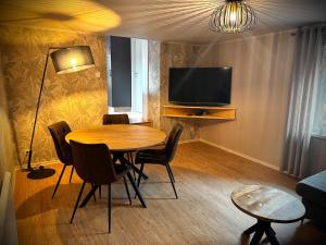a living room with a table and a television at La Tanière du Katz in Dabo